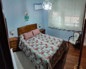 um quarto com uma cama, uma cadeira e uma janela em Apartamento Turístico Menéndez Pelayo -Vigo em Vigo