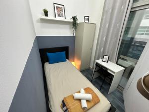 a small bedroom with a bed and a table at Partition Room 5 Mins to Mashreq Metro in Dubai