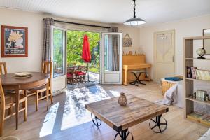 een woonkamer met een tafel en een piano bij La Halte Provençale vaste gîte T1 avec jardin entre mer et collines in Roquevaire