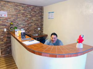 a man sitting at a counter in a bar at Hostal Casa San Fernando Tumbaco in Quito