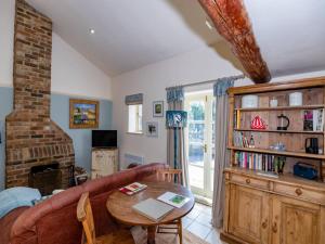 a living room with a couch and a table at Pass The Keys Wilf's Barn, Wedmore a romantic cottage for two in Wedmore