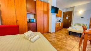 een kleine kamer met een bed en een keuken bij Appartamento Smith Moscato - Affitti Brevi Italia in Bardonecchia