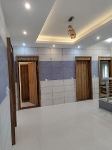 a bathroom with three mirrors and a ceiling at Shree Skanthas inn in Palni