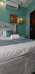a bedroom with a large white bed with blue walls at Homes By Sandra in Kilifi