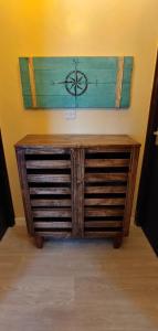 a wooden cabinet with a clock on a wall at Homes By Sandra in Kilifi
