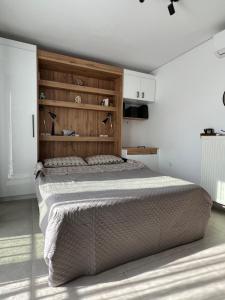 a bedroom with a large bed with a wooden headboard at Olympus! Athens! Studio in the Sky!! 20' walk to the Acropolis in Athens