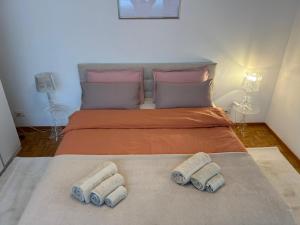 una camera da letto con un letto con tre asciugamani di Lugano Ferienwohnung nähe vom See mit Swimmingpool & Sauna a Paradiso