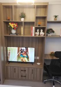 an entertainment center with a television in an office at Lovella Suites Gold Park in Nairobi