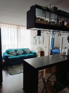 ein Wohnzimmer mit einem blauen Sofa und einem Tisch in der Unterkunft Departamento Aquamar in Viña del Mar