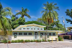 une maison jaune avec des palmiers devant elle dans l'établissement Beautifully Updated, 4 Bedroom Pool Home, 50 Yards to the Beach!! Captiva Escapade, à Captiva