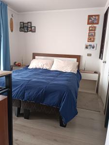 ein Schlafzimmer mit einem Bett mit einer blauen Decke in der Unterkunft Departamento Aquamar in Viña del Mar