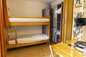 une chambre avec deux lits superposés et une table dans l'établissement Pont du Verdon - 207 - Vue montagne 4 pers, à La Foux