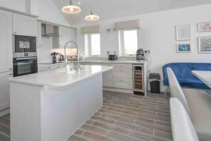 a kitchen with white cabinets and a counter top at Harbour Sands - 4 Bed With Stunning Coastal Views in Amble