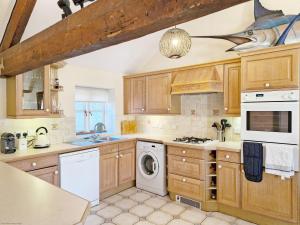 eine Küche mit Holzschränken und einem Fisch an der Decke in der Unterkunft The Old Sail Loft - Emsworth in Emsworth