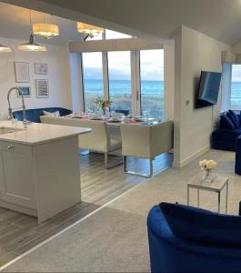 a kitchen and living room with a table and chairs at Harbour Sands - 4 Bed With Stunning Coastal Views in Amble