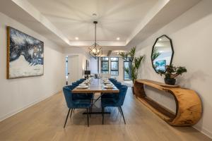 uma sala de jantar com uma mesa com cadeiras azuis e um espelho em Verbier 1-103 / Vast & Luxurious 3 bedroom em Mont-Tremblant