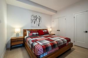 um quarto com uma cama, 2 candeeiros e uma porta em Verbier 1-103 / Vast & Luxurious 3 bedroom em Mont-Tremblant