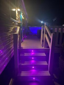 um conjunto de escadas com luzes roxas em Tattershall Lakes Kingfisher Caravan 8 berth with Hot tub & WiFi em Tattershall