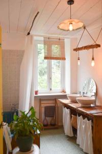 La salle de bains est pourvue de 2 lavabos et d'une fenêtre. dans l'établissement La Maison des Hirondelles Forêt de Brocéciande, à Saint-Malon-sur-Mel