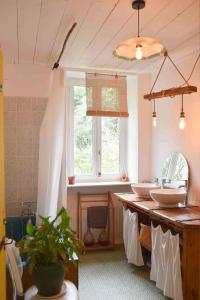 a bathroom with two sinks and a window at La Maison des Hirondelles Forêt de Brocéciande in Saint-Malon-sur-Mel +27 photos
