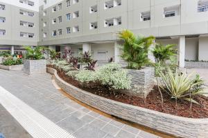 une passerelle devant un bâtiment avec des plantes dans l'établissement Capital O 93593 Pelangi Loftville City, à Tangerang