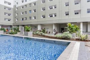 Capital O 93593 Pelangi Loftville City في تانغيرانغ: فندق فيه مسبح امام مبنى