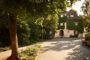 Gästehaus Englischer Garten في ميونخ: منزل على شارع فيه شجرة وممر