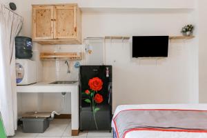 a kitchen with a black refrigerator with a rose on it at Capital O 93593 Pelangi Loftville City in Tangerang