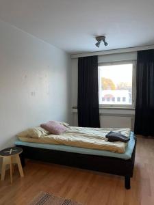 een slaapkamer met een bed, een raam en een tafel bij Apartment Kopin2 in Kokkola