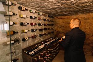 a man looking at a wall of wine bottles at Resort Fazenda 3 Pinheiros in Engenheiro Passos