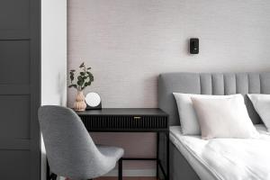 - une chambre avec un bureau et une chaise à côté d'un lit dans l'établissement Flatbook - City Center Apartments Kamienna Grobla, à Gdańsk