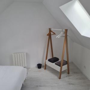 - une chambre blanche avec un lit et une échelle en bois dans l'établissement Gite Les Mouettes Blessées, au Crotoy 1 autre photo