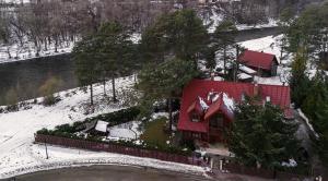 dom z czerwonym dachem w śniegu w obiekcie Willa nad Popradem w mieście Piwniczna