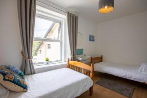 Un dormitorio con dos camas y una ventana. en Atlantic Court, en Bude