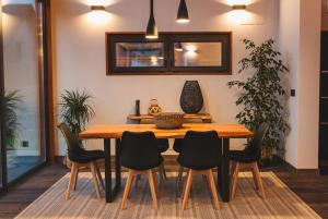 a dining room with a wooden table and chairs at Cabanas do Pico 2B in Canto da Areia +10 photos
