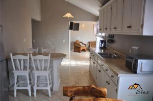 a kitchen with a sink and a counter with stools at Departamentos - Cabañas Sias in Creel