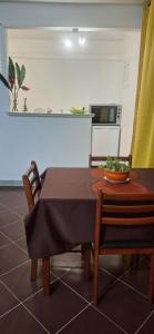 - une table à manger avec des chaises et un bol dans l'établissement Escale chez Joëlle & Alain, au Lamentin