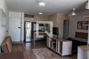 a living room with a couch and a kitchen at Maravilhoso Studio Flat Apto no Bosque - Campinas in Campinas