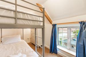 a bedroom with a bunk bed and a window at 1 Ruscon Cottage in Brancaster