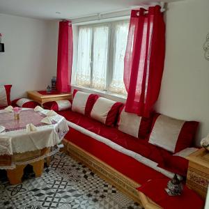 un soggiorno con divano rosso e finestra di MAISON SPACIEUSE a Menars