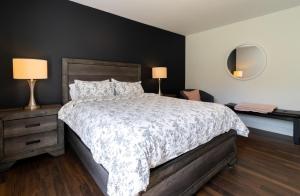 a bedroom with a bed and two lamps and a mirror at Détente Orford 117 condo / chalet in Orford