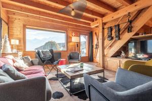 a living room with couches and a table in a cabin at SmartStay - Chalet face au mont Blanc in Sallanches