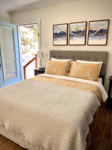 a bedroom with a large bed with four pictures on the wall at Avenue of the Giants Pepperwood Place (#2) 