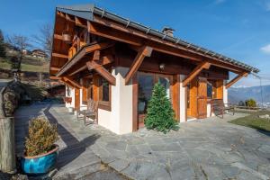a log cabin with a porch and a christmas tree at SmartStay - Chalet face au mont Blanc in Sallanches