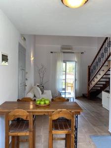 una sala da pranzo con tavolo e cesto di frutta di Calma Cottage a Città di Skiathos