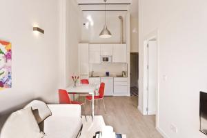 ein weißes Wohnzimmer mit einem Tisch und roten Stühlen in der Unterkunft Casa Miravalle Darro in Granada