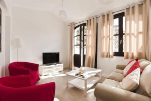 un soggiorno con sedie rosse, divano e TV di Casa Miravalle Darro a Granada