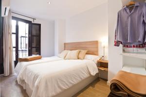 um quarto com uma cama e uma camisa pendurada numa parede em Casa Miravalle Darro em Granada