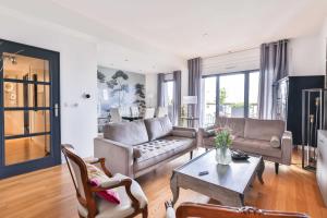 sala de estar con sofá y mesa en Refined bright apt next to the Seine, en Courbevoie