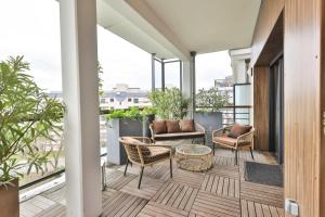 - Balcón con sillas y mesa en Refined bright apt next to the Seine, en Courbevoie